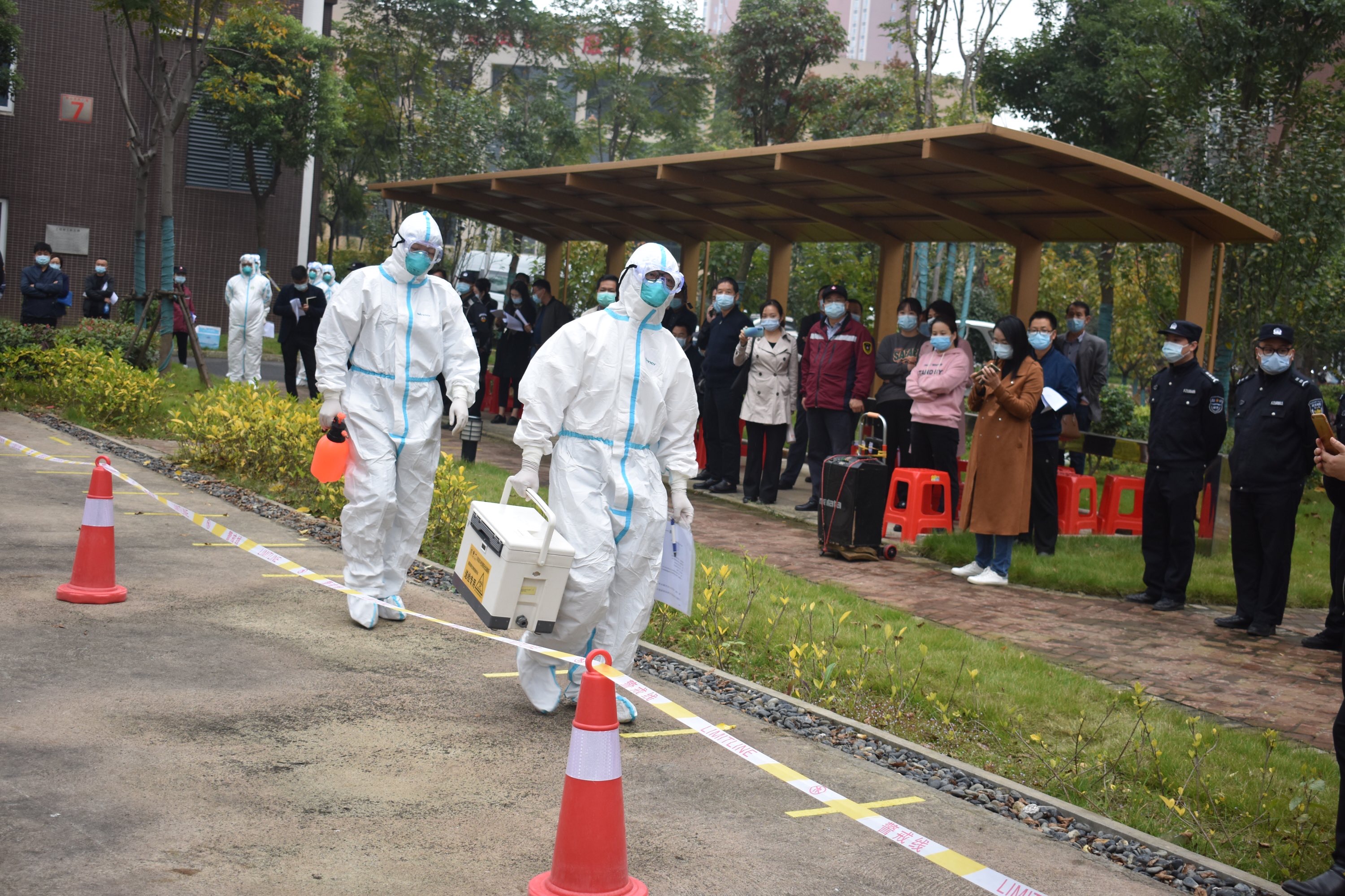 暴雨下核酸检测采集员坚持工作_寂地员员_多地取消全员核酸